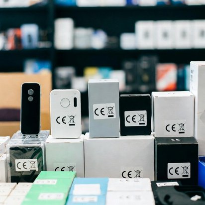 Vraag een offerte aan bij TÜV NORD voor CE-markering Elektronische apparaten en verpakkingen met zichtbare CE-markering, uitgestald op dozen in een winkelomgeving.