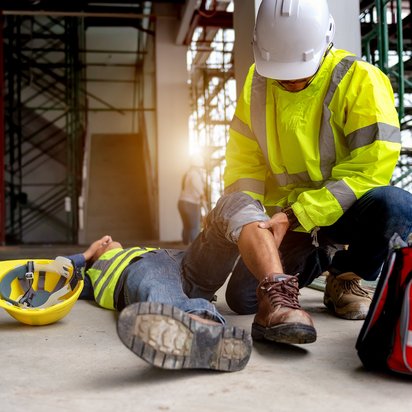 Vraag een offerte aan bij TÜV NORD voor Veiligheidsladder Bouwmedewerker verleent eerste hulp aan gewonde collega op bouwplaats na arbeidsongeval.