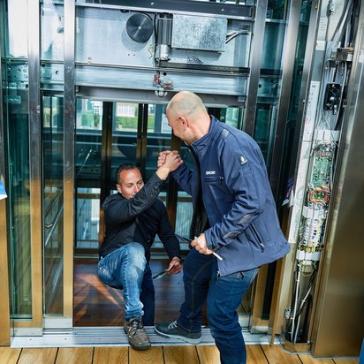 Veilig werken in en rondom liften Medewerker van TÜV NORD zit klaar om contactvragen te beantwoorden.