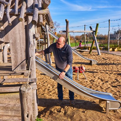Vraag keuring aan Inspecteur voert een veiligheidskeuring uit van een speeltoestel op een speeltuin.