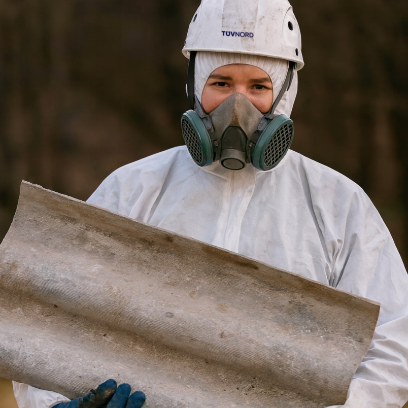 Contact opnemen met TÜV NORD Personen in beschermende kleding tijdens het uitvoeren van asbestverwijdering