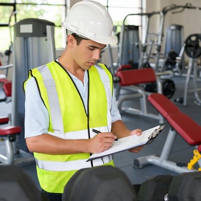 Vraag een offerte aan Inspecteur voert een veiligheidskeuring uit en noteert bevindingen in sportomgeving.
