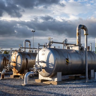 Vraag een offerte aan bij TÜV NORD voor ATEX certificering Industriële opslagtanks met leidingen en afsluiters op een buitenterrein.