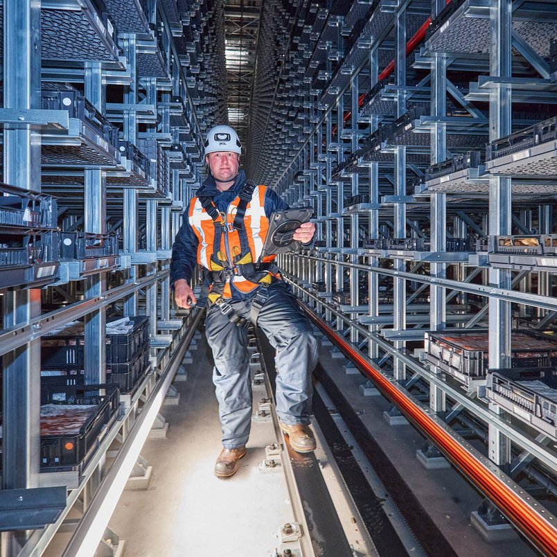 Contact opnemen met TÜV NORD Inspecteur voert een veiligheidsinspectie uit in een magazijn met hoge stellingen.