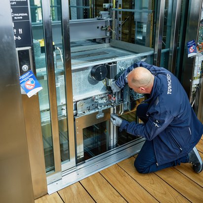 Plan een keuring Inspecteur controleert de technische onderdelen van een liftinstallatie.